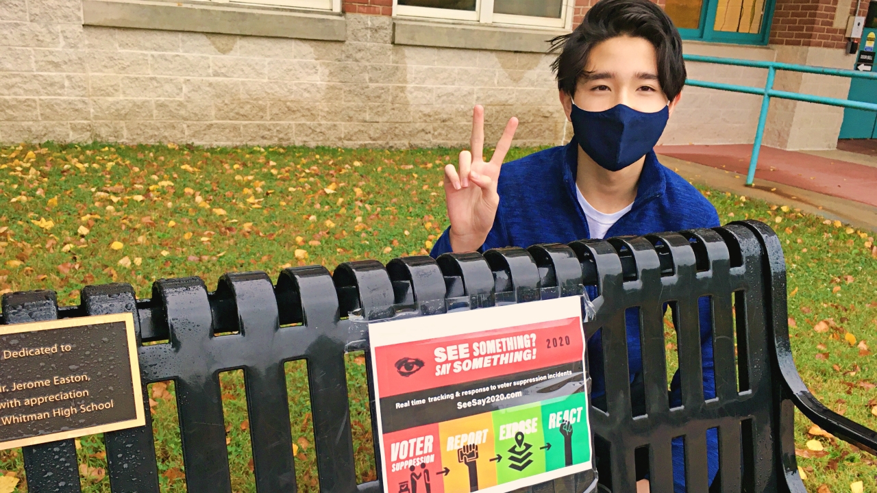 Student posting in front of voting sign